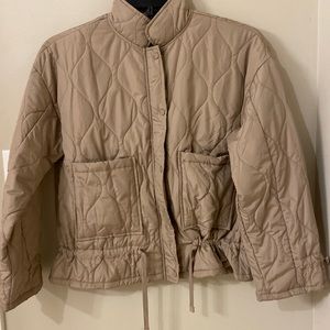 Lightweight tan MINE jacket with an adjustable waist and adjustable sleeves